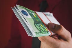 de mens in rood kostuum houdt een pakje van geld in zijn hand op rode achtergrond stand stock afbeeldingen de mens in rood kostuum houdt een pakje van geld in zijn hand op rode achtergrond stand stock afbeeldingen