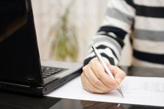 De mens schrijft document of bestudeert thuis met laptop naast stock fotografie De mens schrijft document of bestudeert thuis met laptop naast stock fotografie