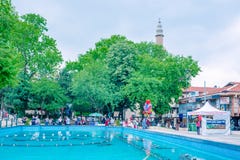 de mensen lopen rond pool bij Orhangazi-Vierkant in Slijmbeurs, Turkije stock foto's de mensen lopen rond pool bij Orhangazi-Vierkant in Slijmbeurs, Turkije stock foto's