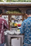 De mensen van Indonesië bereiden voedsel bij een uitstekende houten de duwkar van het straatvoedsel in voor Djakarta, Indonesië royalty-vrije stock afbeelding De mensen van Indonesië bereiden voedsel bij een uitstekende houten de duwkar van het straatvoedsel in voor Djakarta, Indonesië royalty-vrije stock afbeelding