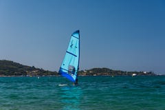 De mensen is wind surfend op het blauwe overzees van Corsica Blauwe windbranding in voorgrond, de aard van Corsica op achtergrond royalty-vrije stock foto's De mensen is wind surfend op het blauwe overzees van Corsica Blauwe windbranding in voorgrond, de aard van Corsica op achtergrond royalty-vrije stock foto's