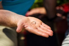 De mensenholding in zijn hand een ring, de kerel geeft het meisje een ring, a stock fotografie De mensenholding in zijn hand een ring, de kerel geeft het meisje een ring, a stock fotografie