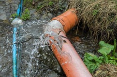 De misvormde waterpijp barstte water die van het wegvloeien royalty-vrije stock foto De misvormde waterpijp barstte water die van het wegvloeien royalty-vrije stock foto