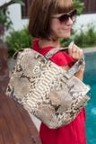 De modieuze zak van de het leer snakeskin python van de vrouwenholding Elegante uitrusting Sluit omhoog van beurs in handen van m Stock Afbeelding De modieuze zak van de het leer snakeskin python van de vrouwenholding Elegante uitrusting Sluit omhoog van beurs in handen van m Stock Afbeelding