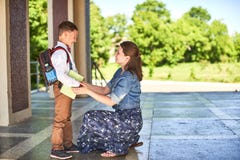 De moeder begeleidt het kind aan school het mamma moedigt student aan die hem begeleiden aan school een gevende moeder bekijkt te royalty-vrije stock foto De moeder begeleidt het kind aan school het mamma moedigt student aan die hem begeleiden aan school een gevende moeder bekijkt te royalty-vrije stock foto