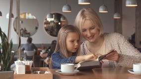 De moeder en de dochter lezen het boek bij de koffie royalty-vrije stock foto De moeder en de dochter lezen het boek bij de koffie royalty-vrije stock foto