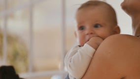 De moeder houdt haar babyzoon op handen stock footage De moeder houdt haar babyzoon op handen stock footage