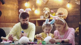 De moeder, de vader en de zoon schilderen eieren De gelukkige familie treft voor Pasen voorbereidingen Leuk weinig kindjongen die stock video De moeder, de vader en de zoon schilderen eieren De gelukkige familie treft voor Pasen voorbereidingen Leuk weinig kindjongen die stock video