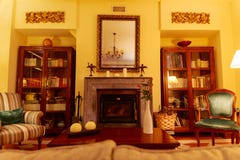 De mooie en comfortabele woonkamer met een centrale open haard, wordt dit omringd door plankenhoogtepunt van boeken Deze foto wer royalty-vrije stock afbeeldingen De mooie en comfortabele woonkamer met een centrale open haard, wordt dit omringd door plankenhoogtepunt van boeken Deze foto wer royalty-vrije stock afbeeldingen