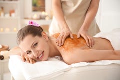 De mooie jonge vrouw die massage met lichaam hebben schrobt royalty-vrije stock afbeelding De mooie jonge vrouw die massage met lichaam hebben schrobt royalty-vrije stock afbeelding