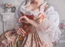 De mooie vrouw in middeleeuwse kledingsholding nam toe Stock Foto De mooie vrouw in middeleeuwse kledingsholding nam toe Stock Foto