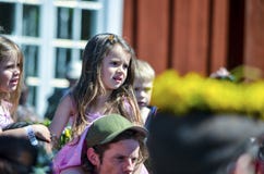 De mooie Zweedse mensen en dissapointed jonge geitjes genieten van traditionele decoratie die van medio de zomerdag kleurrijke kr stock fotografie De mooie Zweedse mensen en dissapointed jonge geitjes genieten van traditionele decoratie die van medio de zomerdag kleurrijke kr stock fotografie