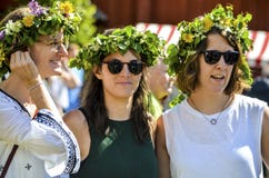 De mooie Zweedse zoete gelukkige vrouw geniet van traditionele decoratie die van medio de zomerdag kleurrijke verlofkroon in zonn stock foto De mooie Zweedse zoete gelukkige vrouw geniet van traditionele decoratie die van medio de zomerdag kleurrijke verlofkroon in zonn stock foto
