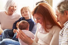 De multizitting van de Generatiefamilie op Sofa With Newborn Baby stock afbeeldingen De multizitting van de Generatiefamilie op Sofa With Newborn Baby stock afbeeldingen