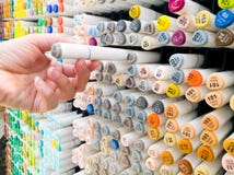 De nadruk op vrouwenhand selecteert de kleurenpen op de plank bij kantoorbehoeftenwinkel stock afbeeldingen De nadruk op vrouwenhand selecteert de kleurenpen op de plank bij kantoorbehoeftenwinkel stock afbeeldingen