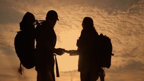De navigatieconcept van het groepswerktoerisme Het gelukkige silhouet van familiewandelaars in aard die in een weg van de smartph stock video De navigatieconcept van het groepswerktoerisme Het gelukkige silhouet van familiewandelaars in aard die in een weg van de smartph stock video