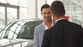 De nieuwe koper inspecteert de geselecteerde auto stock fotografie De nieuwe koper inspecteert de geselecteerde auto stock fotografie