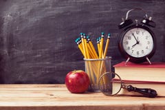 De nouveau au fond d'école avec les livres et le réveil au-dessus du tableau De nouveau au fond d'école avec les livres et le réveil au-dessus du tableau