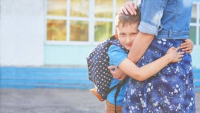 De nouveau ? l'?cole Étreinte heureuse de mère et de fils devant l'école primaire photographie stock libre de droits De nouveau ? l'?cole Étreinte heureuse de mère et de fils devant l'école primaire photographie stock libre de droits