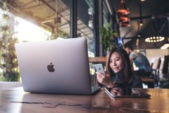 17 de noviembre de 2017: Mujer de negocios asiática que sostiene el teléfono elegante con el ordenador portátil en la tabla de ma foto de archivo libre de regalías 17 de noviembre de 2017: Mujer de negocios asiática que sostiene el teléfono elegante con el ordenador portátil en la tabla de ma foto de archivo libre de regalías
