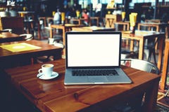 De open laptop computer en de kop van koffie die op een houten lijst in koffie liggen versperren binnenland royalty-vrije stock foto De open laptop computer en de kop van koffie die op een houten lijst in koffie liggen versperren binnenland royalty-vrije stock foto