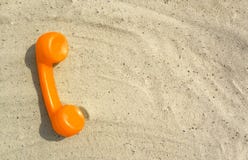 De oranje buis van een oude uitstekende telefoon ligt op het zand royalty-vrije stock afbeeldingen De oranje buis van een oude uitstekende telefoon ligt op het zand royalty-vrije stock afbeeldingen