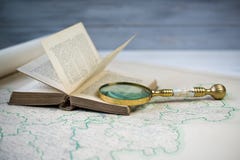 De oro hermosos viejos magnifican el vidrio en el libro antiguo y el mapa viejo imagenes de archivo De oro hermosos viejos magnifican el vidrio en el libro antiguo y el mapa viejo imagenes de archivo