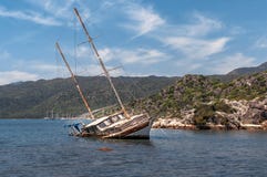 De oude roestige overstroomde zeilboot liep op een ertsader in het overzees, schipbreuk, Turkije vast stock afbeelding De oude roestige overstroomde zeilboot liep op een ertsader in het overzees, schipbreuk, Turkije vast stock afbeelding