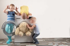 De ouders kochten een nieuwe wasmachine De kinderen proberen om het aan te zetten en het zachte speelgoed te wassen De gelukkige royalty-vrije stock foto De ouders kochten een nieuwe wasmachine De kinderen proberen om het aan te zetten en het zachte speelgoed te wassen De gelukkige royalty-vrije stock foto