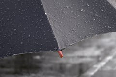 De paraplu met regenachtige dalingen sluit omhoog op de achtergrond van de straatweg Stock Foto De paraplu met regenachtige dalingen sluit omhoog op de achtergrond van de straatweg Stock Foto