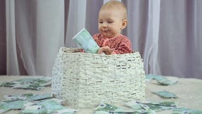 De pasgeboren baby kijkt als geld valt op hem stock video De pasgeboren baby kijkt als geld valt op hem stock video