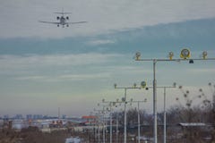 De passen van het passagierslijnvliegtuig over de het landen lichten en het landen bij de luchthaven stock foto's De passen van het passagierslijnvliegtuig over de het landen lichten en het landen bij de luchthaven stock foto's