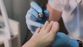 De pedicuremeester in blauwe handschoenen maakt hardwarepedicure in schoonheidssalon stock video De pedicuremeester in blauwe handschoenen maakt hardwarepedicure in schoonheidssalon stock video