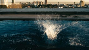 de plons van water na iemand sprong aan het water bij zonsondergang bij een dakpool royalty-vrije stock fotografie de plons van water na iemand sprong aan het water bij zonsondergang bij een dakpool royalty-vrije stock fotografie