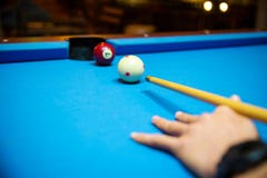 De poolballen op het blauw voelden poollijst met spelerhanden en de stok van het poolrichtsnoer Binnensporten sport en het gokken stock fotografie De poolballen op het blauw voelden poollijst met spelerhanden en de stok van het poolrichtsnoer Binnensporten sport en het gokken stock fotografie