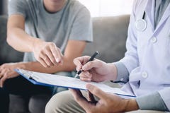 De professionele arts in witte eenvormige togalaag en het geduldige bespreken raadpleegt aan behandeling rehabilitatie en het mak stock afbeelding De professionele arts in witte eenvormige togalaag en het geduldige bespreken raadpleegt aan behandeling rehabilitatie en het mak stock afbeelding