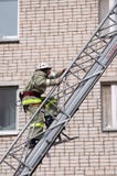 De redder neemt op de brandtrap toe tot een gebouw met meerdere verdiepingen stock foto De redder neemt op de brandtrap toe tot een gebouw met meerdere verdiepingen stock foto