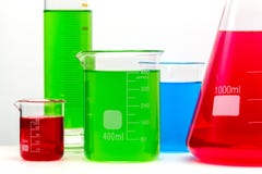 De reeks van het laboratoriumglas met kleurrijke heldere substanties die dichte omhooggaand wordt gevuld royalty-vrije stock fotografie De reeks van het laboratoriumglas met kleurrijke heldere substanties die dichte omhooggaand wordt gevuld royalty-vrije stock fotografie
