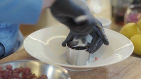 De restaurantchef-kok die cirkelmetaal aanbrengen vormt a cutted tonijnvissen en het maken van een ronde vorm op de grote plaat S stock video De restaurantchef-kok die cirkelmetaal aanbrengen vormt a cutted tonijnvissen en het maken van een ronde vorm op de grote plaat S stock video