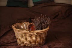 De rieten mand met droge lavendel bloeit, glazen en een fles wijn op het bed royalty-vrije stock afbeeldingen De rieten mand met droge lavendel bloeit, glazen en een fles wijn op het bed royalty-vrije stock afbeeldingen
