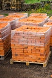 De rode kleibakstenen worden gestapeld op houten pallets Productie van bakstenen van klei stock afbeeldingen De rode kleibakstenen worden gestapeld op houten pallets Productie van bakstenen van klei stock afbeeldingen