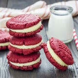 De rode koekjes van de fluweelsandwich met roomkaas het vullen op houten lijst, vierkant Stock Foto De rode koekjes van de fluweelsandwich met roomkaas het vullen op houten lijst, vierkant Stock Foto