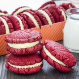 De rode koekjes van de fluweelsandwich met roomkaas het vullen op houten lijst, vierkant Stock Afbeelding De rode koekjes van de fluweelsandwich met roomkaas het vullen op houten lijst, vierkant Stock Afbeelding