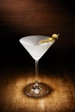 De schijnwerper op één enkele gekoelde martini, met olijven, schoot op DA stock afbeelding De schijnwerper op één enkele gekoelde martini, met olijven, schoot op DA stock afbeelding