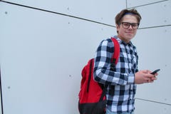 De schooljongen of de student van de jongenstiener in overhemd, die met glazen, rode rugzak glimlachen stock afbeeldingen De schooljongen of de student van de jongenstiener in overhemd, die met glazen, rode rugzak glimlachen stock afbeeldingen