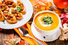 De soep van de de herfstpompoen in een witte plaat met pompoenbrushetta die wordt gediend royalty-vrije stock foto's De soep van de de herfstpompoen in een witte plaat met pompoenbrushetta die wordt gediend royalty-vrije stock foto's