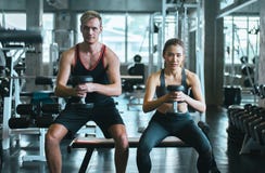 De sportieve de paarman en vrouw oefenen met domoren uit of doen de oefeningen bij gymnastiek royalty-vrije stock afbeelding De sportieve de paarman en vrouw oefenen met domoren uit of doen de oefeningen bij gymnastiek royalty-vrije stock afbeelding