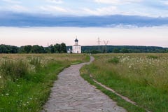 De stenen-bedekte sleep door de Bogolubovo-weide naar Kerk van de Interventie van de Vergine Santa op de Nerl-Rivier royalty-vrije stock afbeelding De stenen-bedekte sleep door de Bogolubovo-weide naar Kerk van de Interventie van de Vergine Santa op de Nerl-Rivier royalty-vrije stock afbeelding
