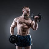 De sterke bodybuilder met zes pakt, perfectioneert abs, schouders, bicepsen in stock fotografie De sterke bodybuilder met zes pakt, perfectioneert abs, schouders, bicepsen in stock fotografie