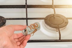 De stodollerbankbiljetten worden gehouden door een mens dichtbij een gaskooktoestel, snel stijgt de prijs van gas royalty-vrije stock foto's De stodollerbankbiljetten worden gehouden door een mens dichtbij een gaskooktoestel, snel stijgt de prijs van gas royalty-vrije stock foto's